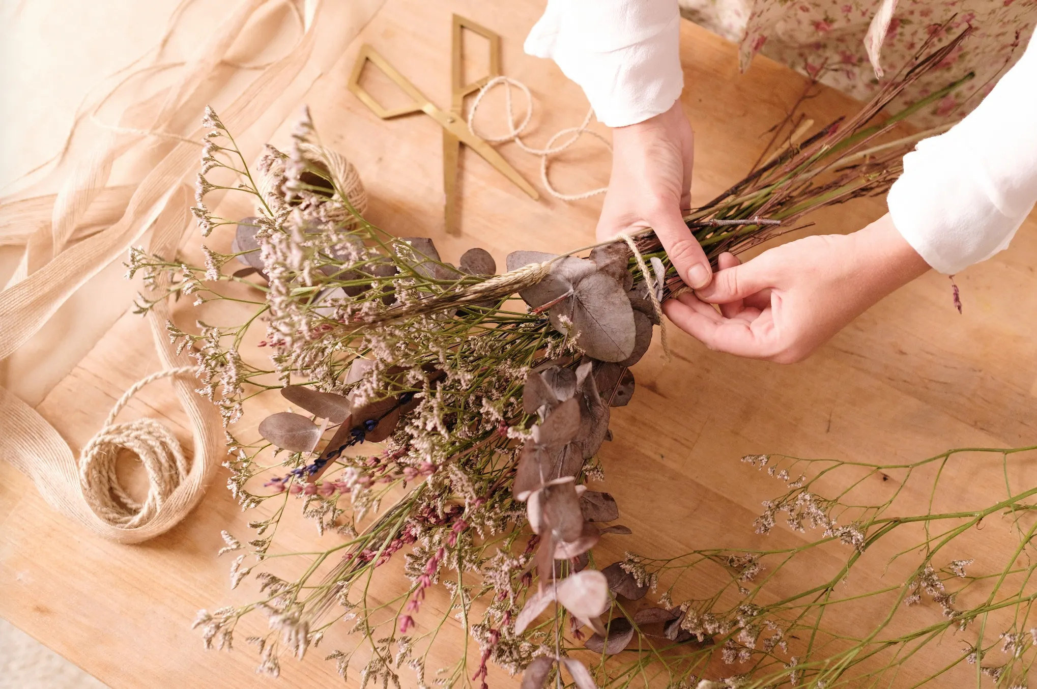Manos de Aída montando un ramo de flor seca